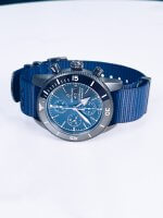 Breitling Superocean Heritage M13313 Outerknown men's watch with a blue dial, black dlc coated case and a blue nato strap.